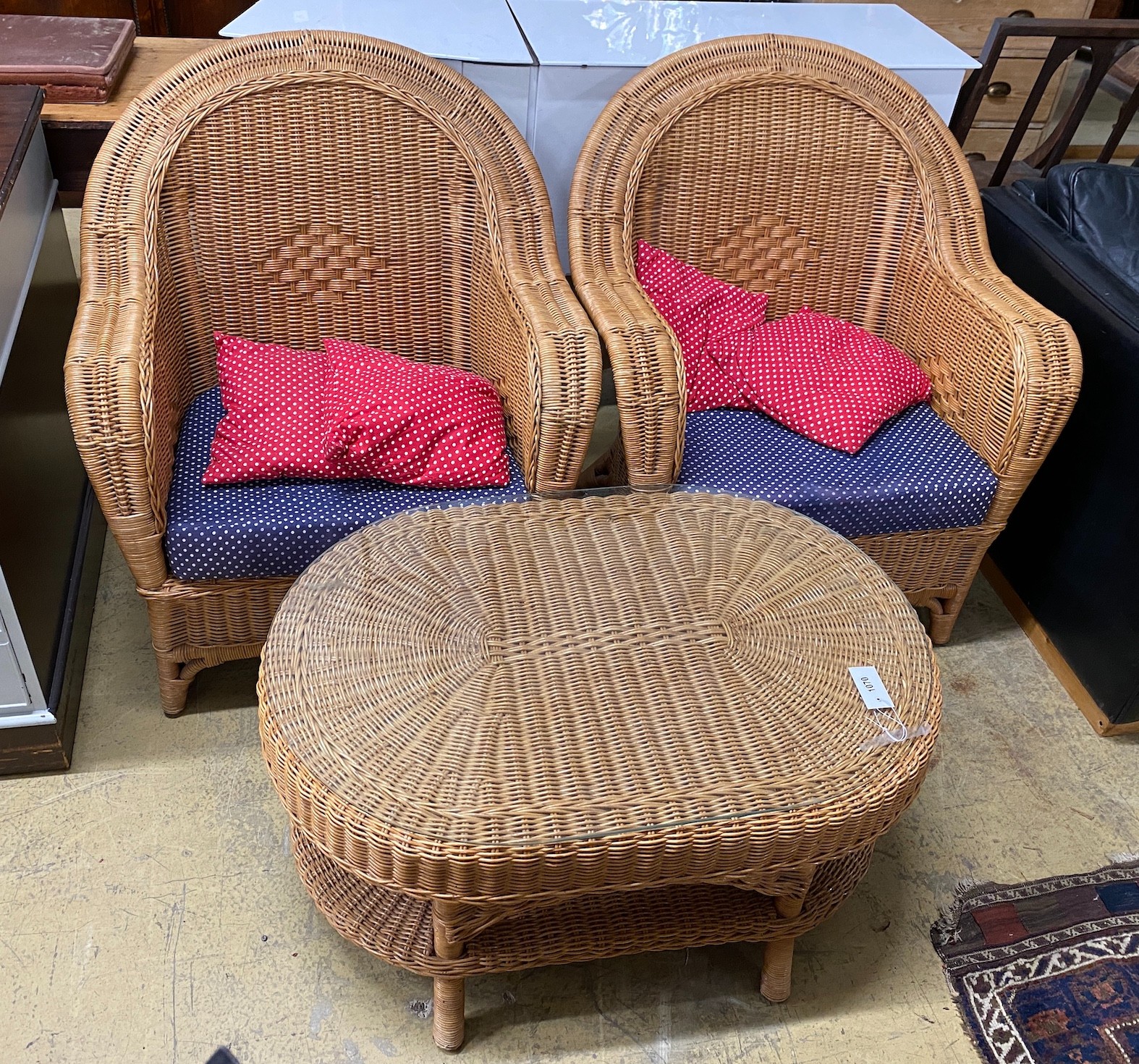 A pair of rattan conservatory chairs and a matching low table